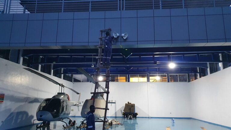 Horn speakers being fitted on the hangar wall