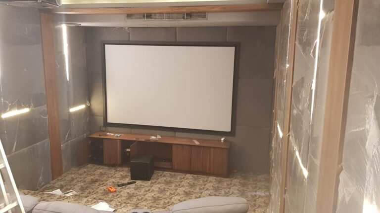Home cinema with large fixed-frame screen and fabric acoustic wall panels
