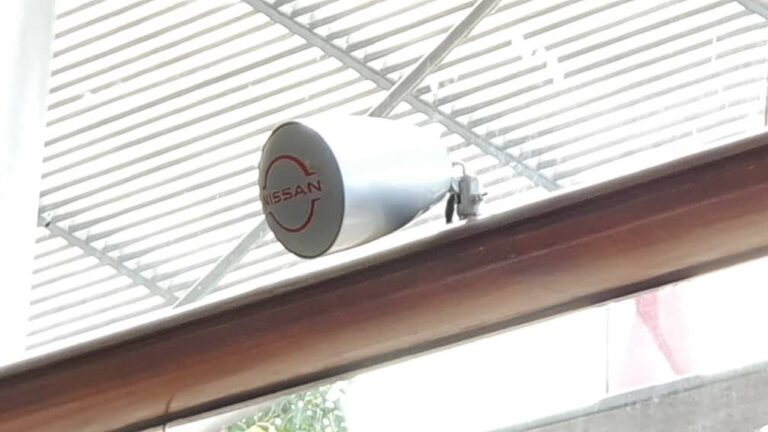 Speaker with Nissan-branded grille on the window rail