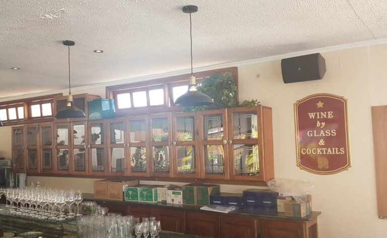 Bar with wall-mounted speakers above the cabinets