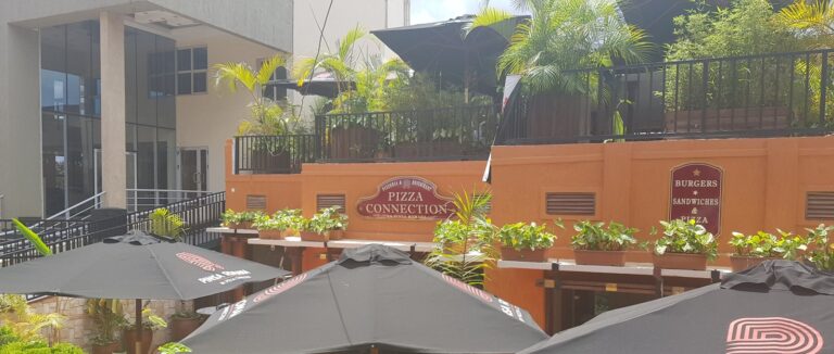 Garden terrace with branded umbrellas at Pizza Connection