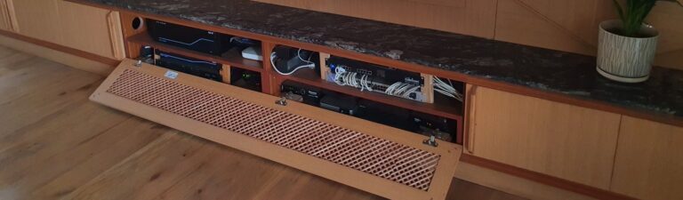 AV cabinet with drop-down vented front showing URC and network equipment
