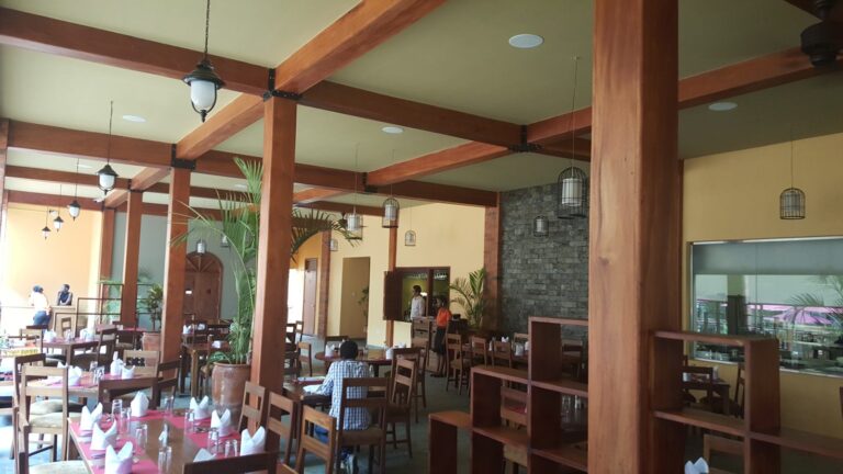 Covered dining hall with ceiling speakers between timber beams